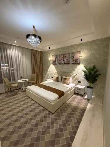 a bedroom with a large white bed and a table at Afruza Hotel in Samarkand