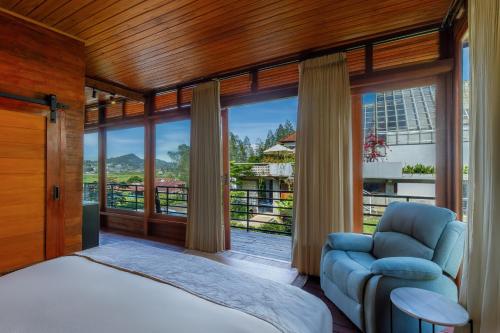 ein Schlafzimmer mit einem Bett, einem Stuhl und einem Fenster in der Unterkunft Alamu Eco Lodge in Bedugul