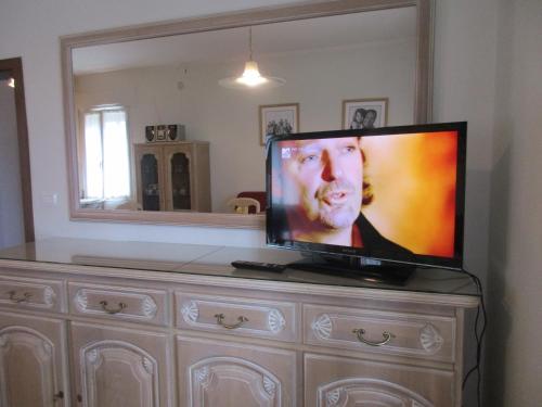 a flat screen tv sitting on top of a dresser at CASA ROMAN ITALIA, Center Sacile in Sacile