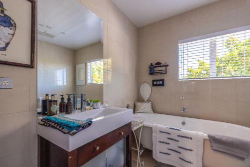 a bathroom with a tub and a sink at L'Appartement Bleu in Waiheke Island