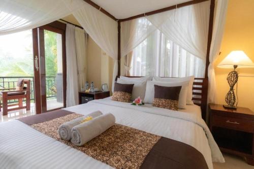 a bedroom with a large bed with white sheets at Secret Forest Hideaway near Ubud in Bangli