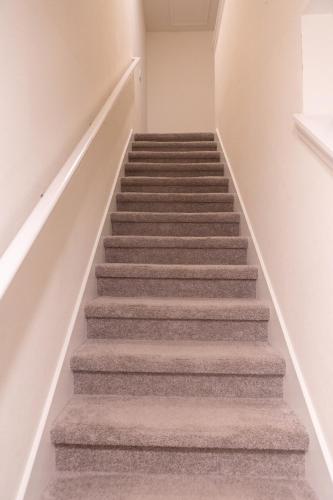 a staircase in a home with grey carpet at South Shore Suites in Wimauma