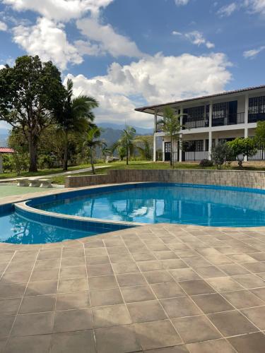 a swimming pool in front of a building at Hotel Campestre Kambra in Garagoa