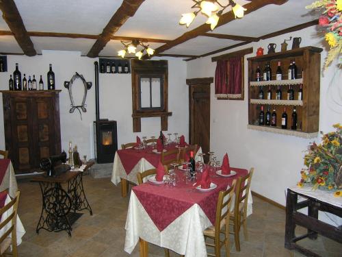 a restaurant with two tables with red napkins and wine bottles at Hotel Martin in Sauze dʼOulx