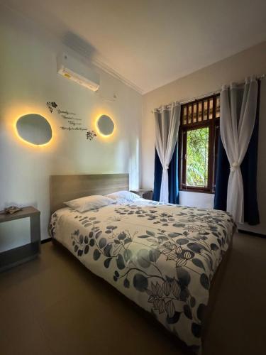 a bedroom with a large bed and a window at Sunset Villa in Senggigi