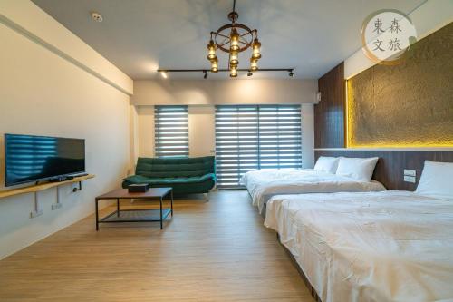a bedroom with two beds and a couch and a tv at 水母漂民宿-免費停車-寵物友善-無門禁24小時進出-東森文旅-包棟優惠中 in Toucheng