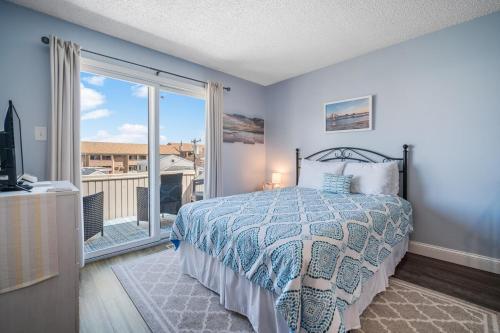 a bedroom with a bed and a balcony at Steps 2 beach Ocean view Pool Parking in Brigantine