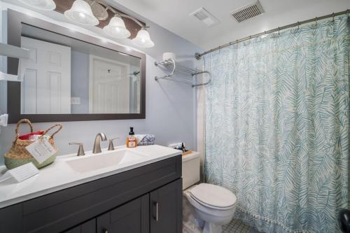 a bathroom with a sink and a shower curtain at Steps 2 beach Ocean view Pool Parking in Brigantine