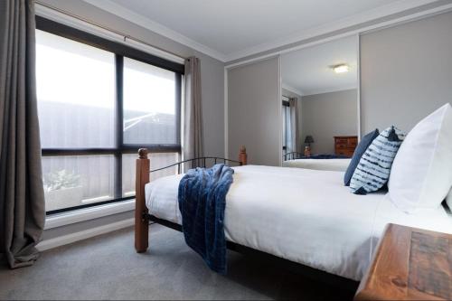 a bedroom with a bed and a large window at Happy Tails Devonport in Devonport
