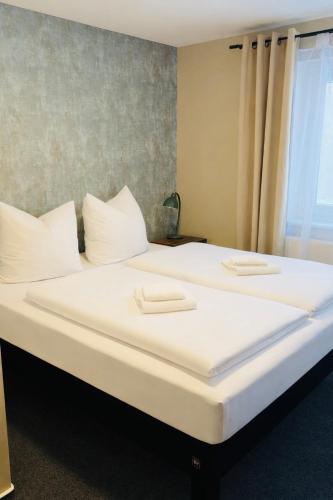 two large white beds in a room with a window at Die Grenzburg in Güstrow