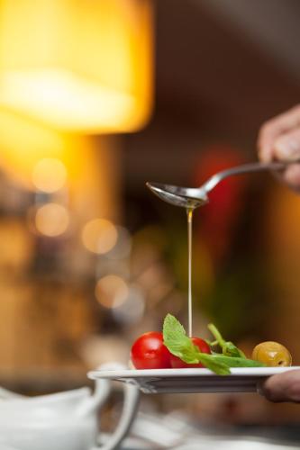 a person is serving food on a plate with a spoon at Buyukhanli Park Hotel in Ankara