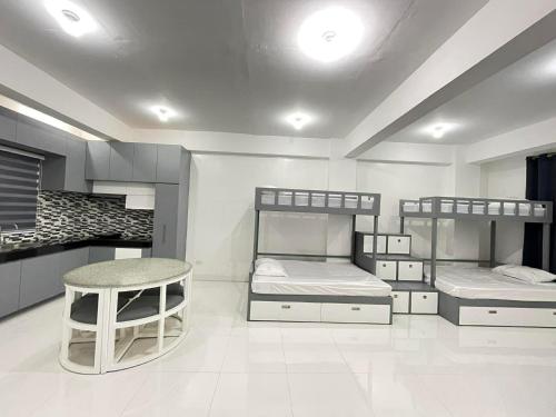 a room with two bunk beds and a kitchen at Host Homes RM201 Independencia St in San Fernando