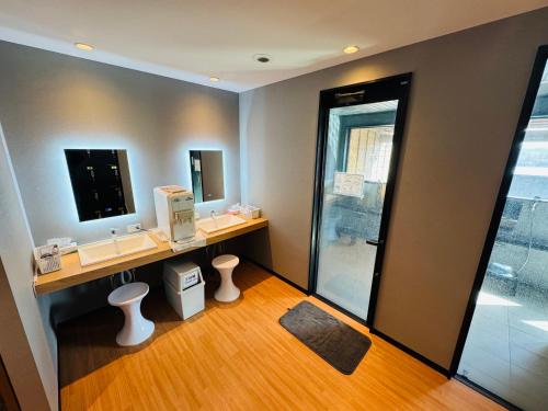a bathroom with two sinks and a mirror and a shower at Shoji Lake Hotel in Fujikawaguchiko