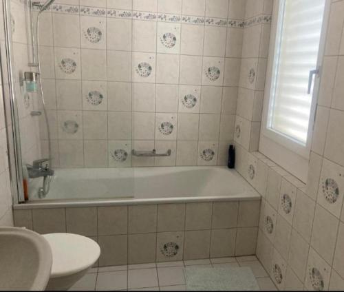 a bathroom with a tub and a toilet and a sink at Gersau Hotel Fähri in Gersau