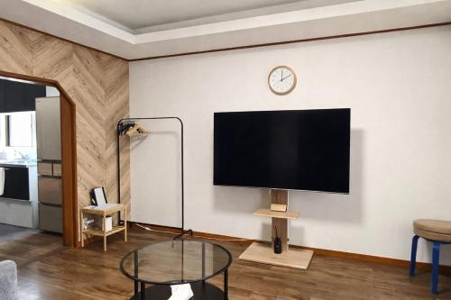 a living room with a large flat screen tv on a wall at 富山駅徒歩15分 環水公園徒歩8分 旅行拠点に最適 和モダン空間でゆったり滞在 in Toyama