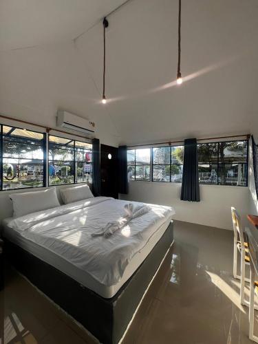 a large bed in a room with windows at มาทาเลรีสอร์ท in Ang Thong