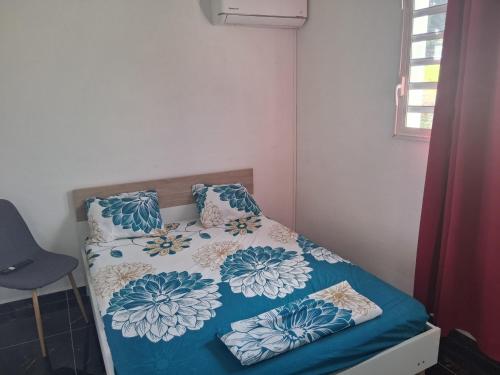 a small bedroom with a bed with a blue comforter at Kaz o ti plezi in Sainte-Rose