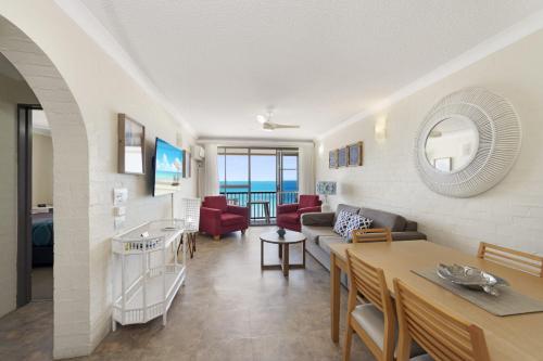 a living room with a couch and a table at Don Pancho Beach Resort in Bargara