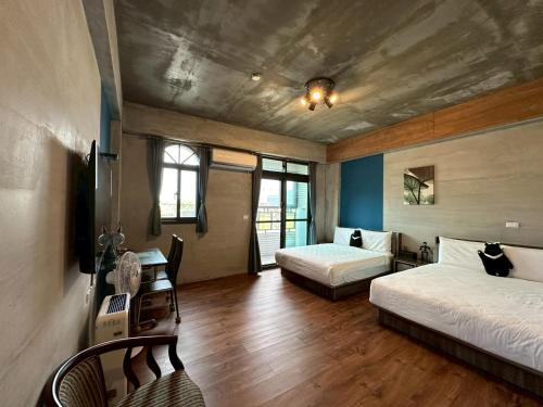 a bedroom with two beds and a desk with a television at Bear&Best Homestay in Yuli