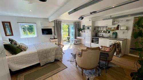 a bedroom with a bed and a kitchen with a counter at Dove Cottage in Auckland