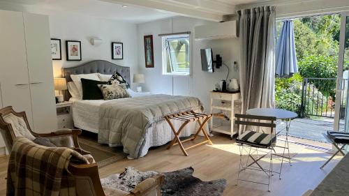 a bedroom with a bed and a balcony at Dove Cottage in Auckland
