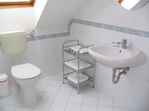biała łazienka z toaletą i umywalką w obiekcie Tölgyes Apartment w Hajduszoboszlo