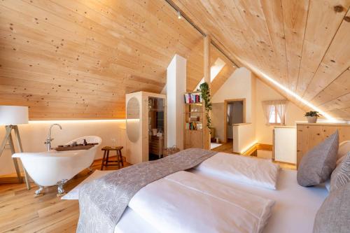 a bedroom with a bed and a tub and a sink at Ebner 1822 in Gnesau