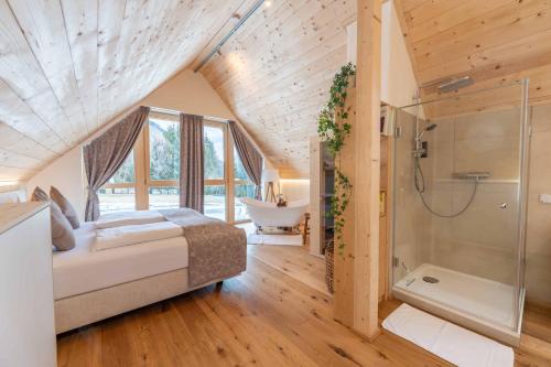 a bedroom with a bed and a bathroom with a tub at Ebner 1822 in Gnesau