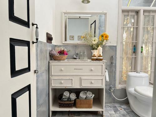 a bathroom with a white dresser and a sink at Crepe Ginger Home Stays in Hariharpur