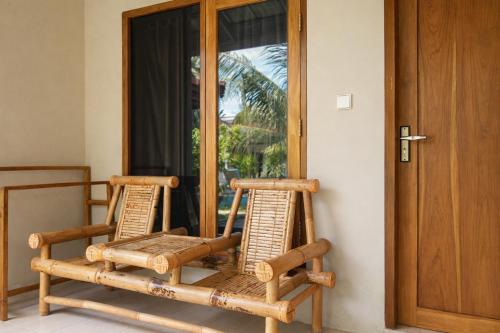 a pair of chairs sitting in front of a door at GGuesthouse in Kuta Lombok