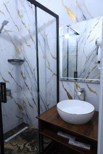 a bathroom with a white sink and a mirror at FIRDAVS HOTEL in Navoi