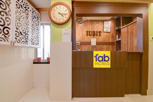 a clock is on a wall in a room at FabHotel Iubit in kolkata