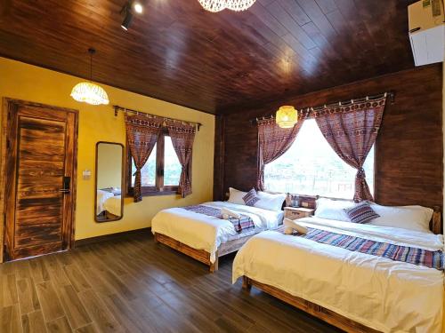 a bedroom with two beds and a window at PiTu Homestay in Dồng Văn