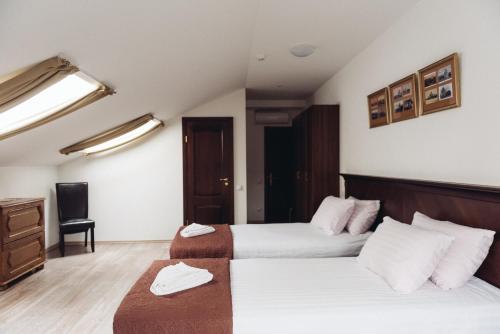 a hotel room with two beds and a desk at Biplan City in Daugavpils