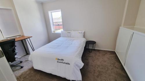 a small bedroom with a bed with a white comforter at Natural Residence 天然居 in Auckland