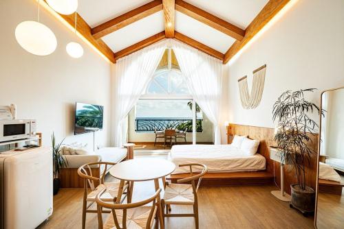 a bedroom with a bed and a table and chairs at Stay Cherry in Seogwipo
