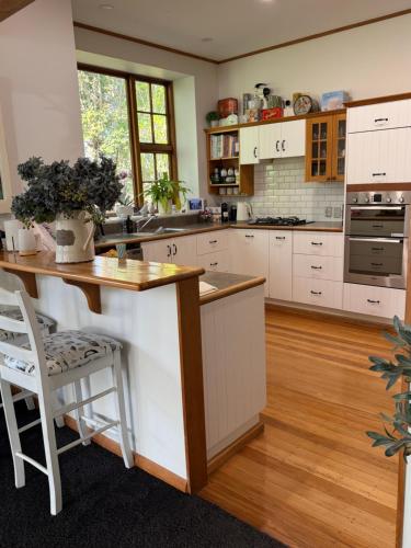 a kitchen with white cabinets and a wooden counter top at Peaceful Homestay 7 Minutes from Christchurch Airport in Christchurch