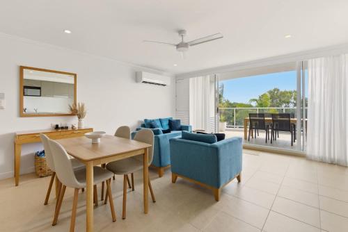 a living room with a table and chairs and a dining room at Oceanview Oasis in Urangan