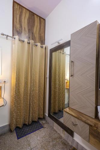 a bathroom with a shower and a large mirror at Matrika Homestay in Lucknow