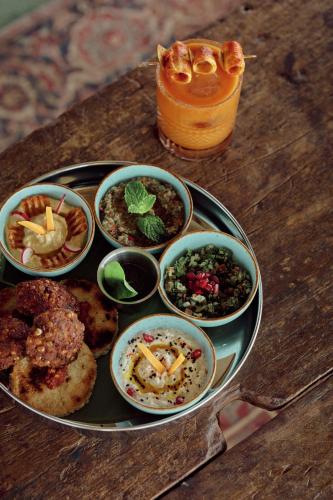 a plate of food with bowls of food on a table at UNU Boutique Hotel -- Adults Only -- in Ahangama