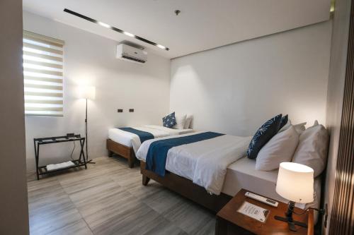 a hotel room with two beds and a lamp at Coron 180 Hotel in Coron