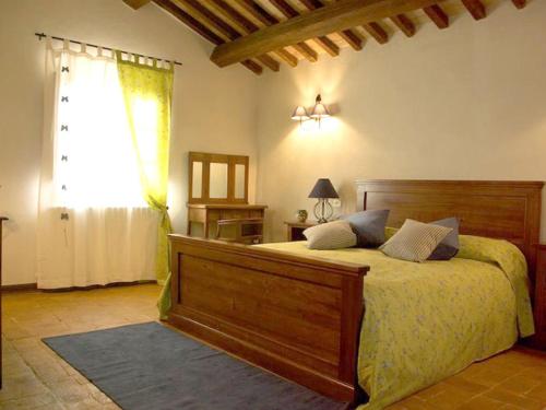 - une chambre avec un grand lit en bois et une fenêtre dans l'établissement Agriturismo Terra Sabina, à Poggio Mirteto