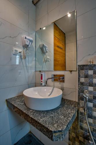ein Badezimmer mit Waschbecken und Spiegel in der Unterkunft Hotel Sea Sapphire in Calangute