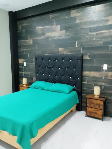 a bedroom with a bed and a brick wall at Casa en Paraíso Cuautla Morelos in Cuautla Morelos