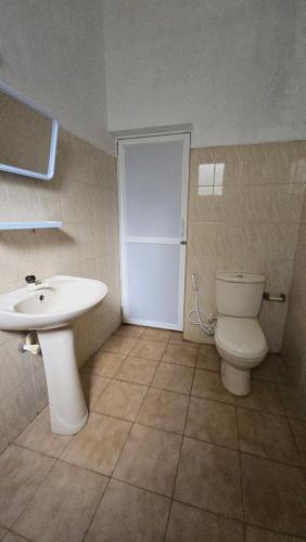 a bathroom with a white toilet and a sink at Stay Suite in Mahiyangana