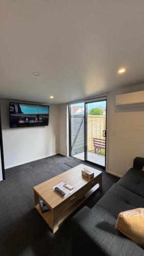 a living room with a couch and a coffee table at Tiny Home in Mosgiel in Mosgiel