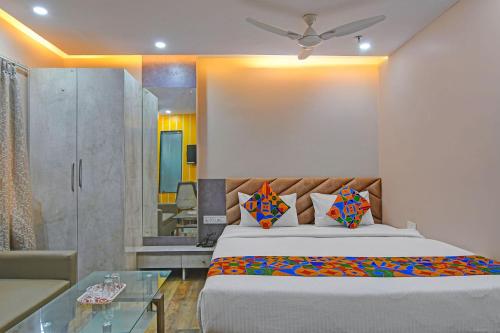 a bedroom with a bed and a glass table at FabHotel Disa in kolkata