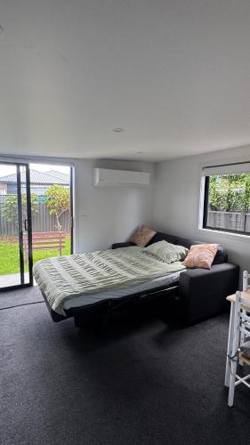 a bedroom with a large bed in a room at Tiny Home in Mosgiel in Mosgiel