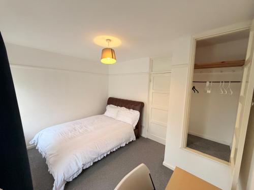 a small bedroom with a bed and a mirror at Precious House 2 in Leicester