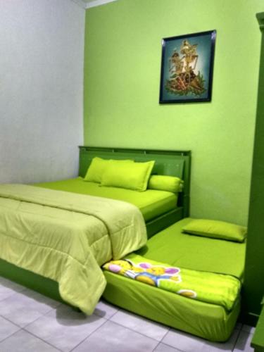 a bedroom with two beds and a couch in it at Ruqita Homestay in Airtabit